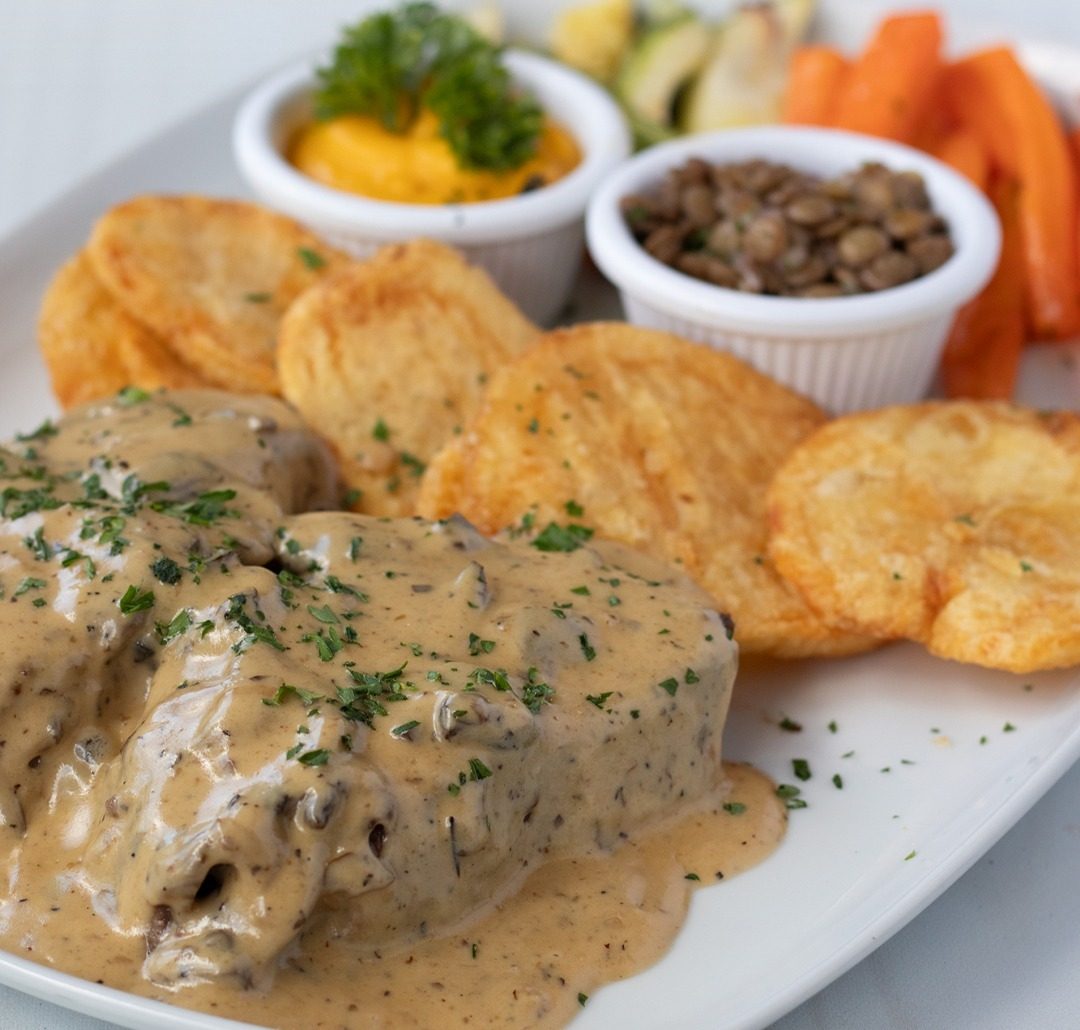 Medallón en salsa cremosa de champiñones, con papas doradas y vegetales frescos