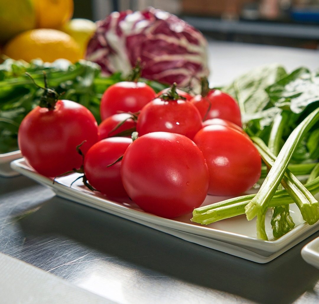 Vegetales y frutas frescas sobre el mesón de acero de la cocina